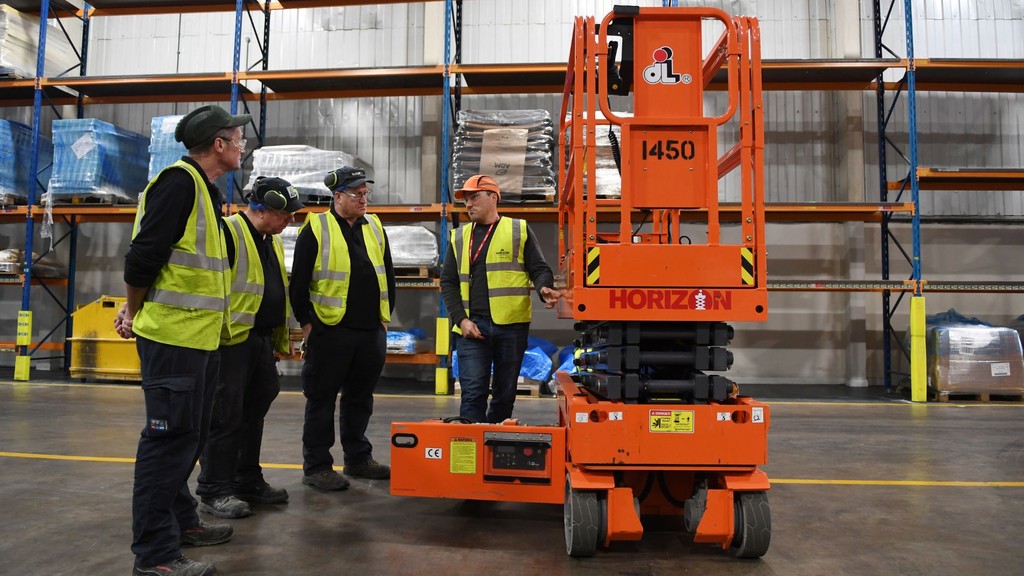3 MEWP operators training in front of pallet racking