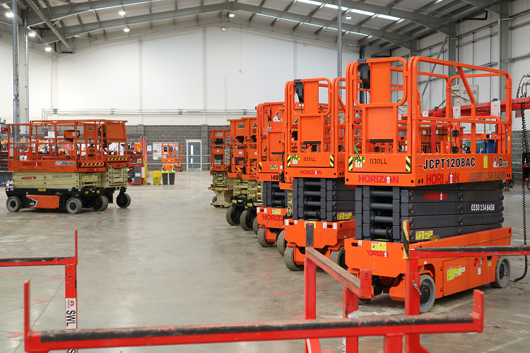 8 electric scissor lifts being charged inside Horizon Platforms' workshop