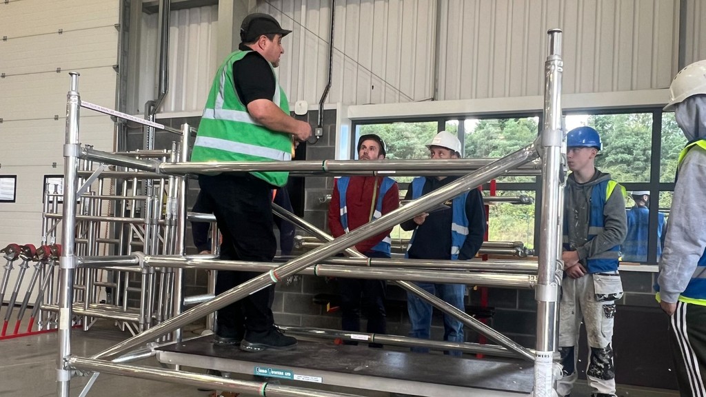 Horizon PASMA instructor shows people in PPE how to build mobile scaffold towers