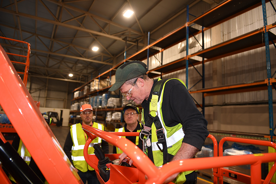 One man on a mast boom lift cherry picker looking at the controls with the IPAF training helping