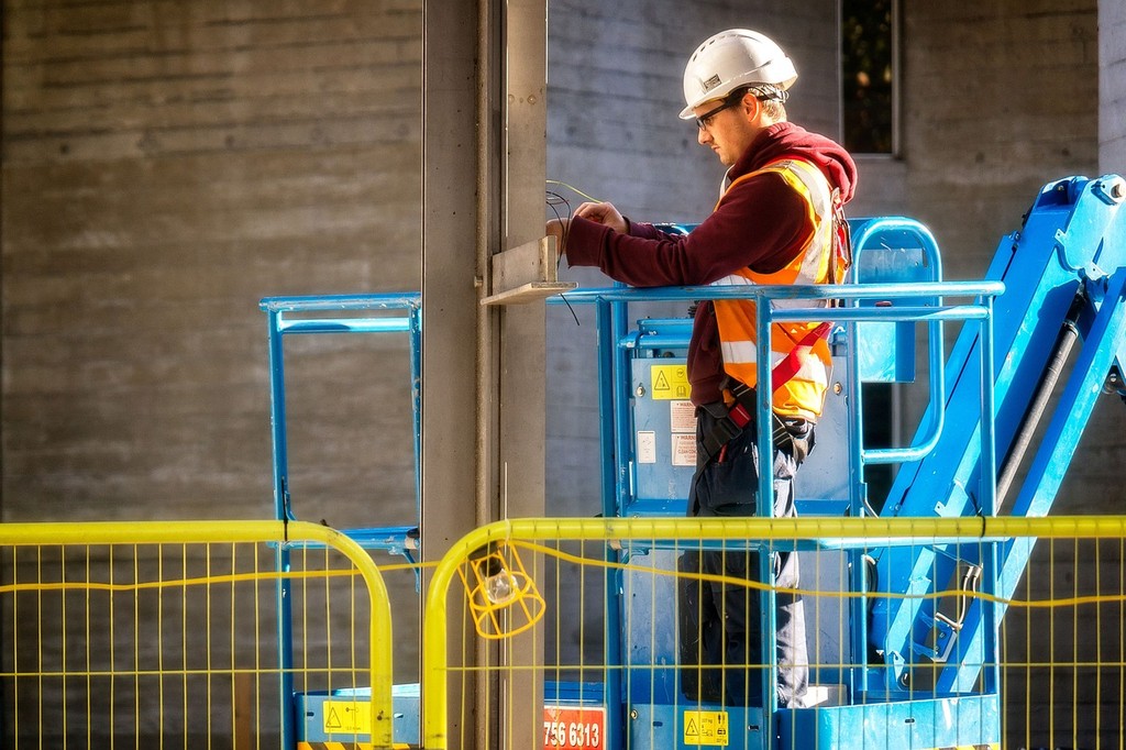 electrician working in a cherry picker on a construction site